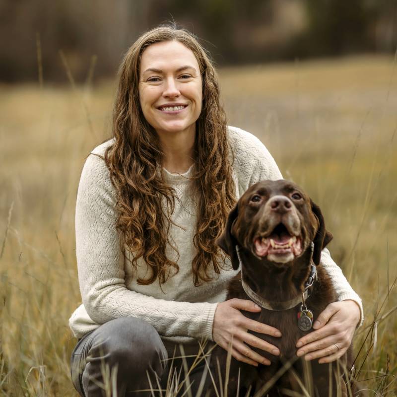 Woman, dog in field